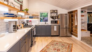 Una cocina moderna con armarios grises, electrodomésticos de acero inoxidable y suelo de madera.
