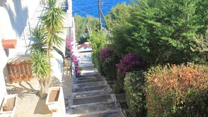 A staircase leading down to a beach with a clear view of the sea. - Daskalio Resort Adamis (Lavreotiki)