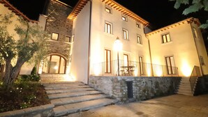 A stone building with a staircase leading to a balcony. - Il Borgo di Villa Cellaia (Dicomano)