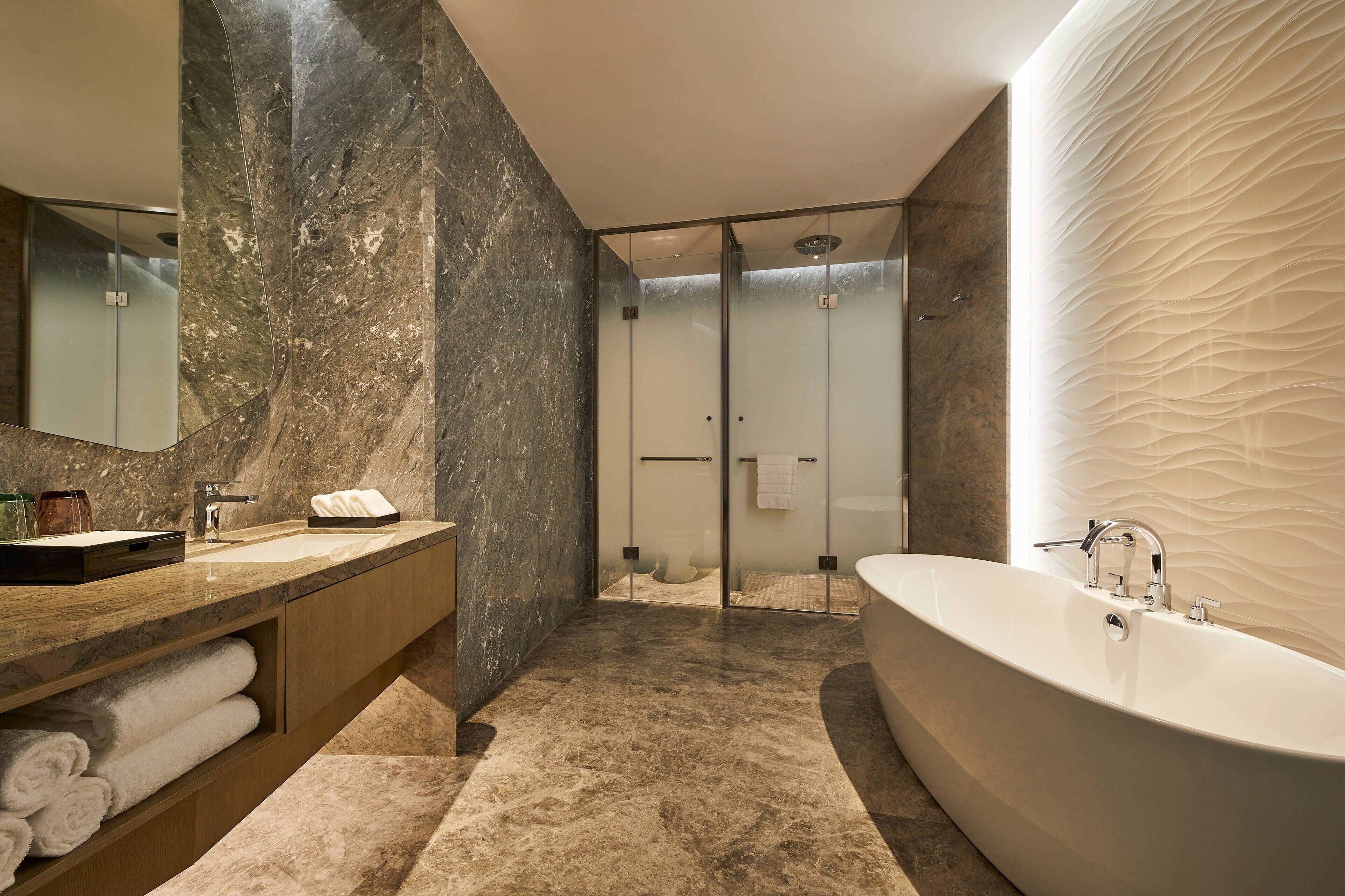 A modern bathroom with a freestanding bathtub, a vanity with a sink, and a glass-enclosed shower area.