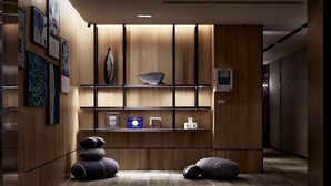 A modern lobby with wooden paneling, a reception desk, and a coffee machine. - Haifu Hotel & Suites (Jincheng)