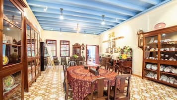 A dining area with a round table, chairs, and patterned floor tiles.