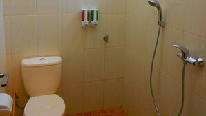 A small bathroom with a toilet, a shower, and a window. - Villa Batu 2 kamar 5 dekat Museum Angkut (Batu)