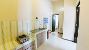A kitchen with a built-in stove, a sink, and a water dispenser. - Villa Batu 2 kamar 5 dekat Museum Angkut (Batu)