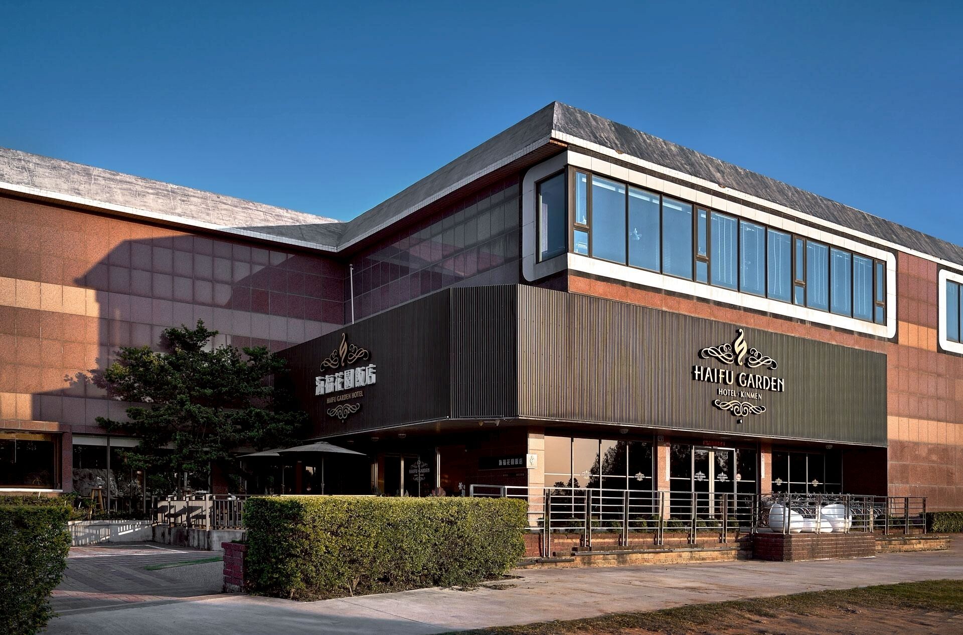A modern building with a large glass facade and signage for Haifu Garden Hotel.
