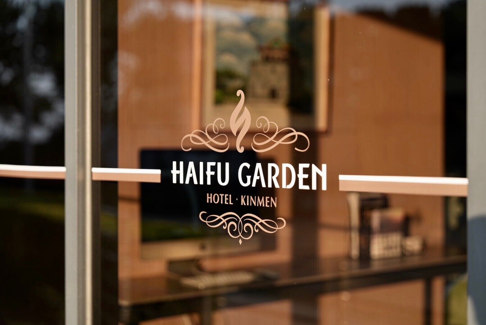 En hotellskylt med namnet ”HAIFU GARDEN HOTEL KIMMEN” och dekorativa element.