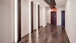 A modern hallway with wooden flooring, white walls, and a dark ceiling. - Hatch NAGAHORI 201 (Osaka)