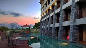 A hotel with a swimming pool, outdoor seating, and a stone facade. - The Batu Villas No 2 near Jatim Park (Batu)