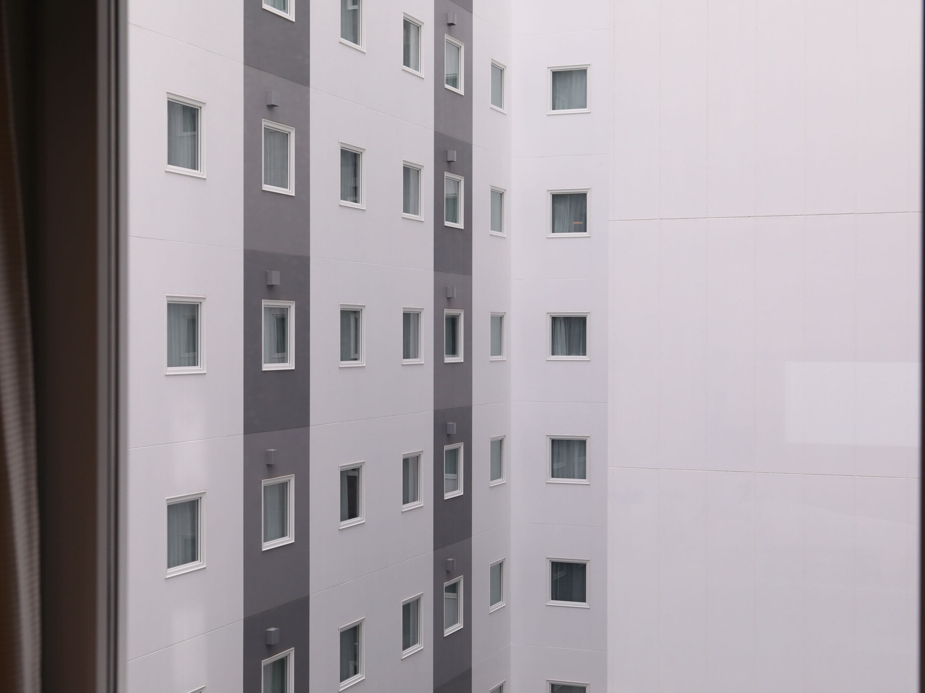 A multi-story building with a consistent window pattern and a neutral color scheme.