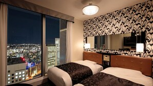 A hotel room with two beds, a large window with a city view, a patterned wall, and a ceiling light. - APA Hotel & Resort Yokohama Bay Tower (Yokohama)