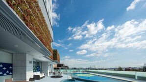A rooftop pool area with a view of the city skyline, including a bridge. - APA Hotel & Resort Yokohama Bay Tower (Yokohama)