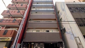 A multi-story hotel with a modern facade, featuring a prominent entrance with a glass door and a sign that reads "Hatch." - Hatch NAGAHORI 202 (Osaka)
