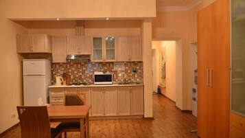 Eenvoudige eenpersoonskamer, uitzicht op tuin | Een kluis op de kamer, een bureau, een strijkplank/strijkijzer