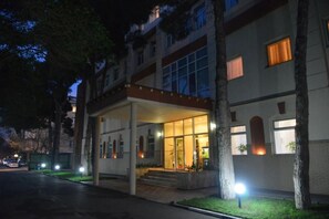 A hotel entrance with a covered walkway, steps leading up to the entrance, and a well-lit facade. - City Mansion ApartHotel (Baku)