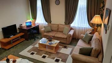 Eenvoudige tweepersoonskamer, uitzicht op tuin | Een kluis op de kamer, een bureau, een strijkplank/strijkijzer