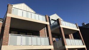 Un edificio a più piani con balconi, facciata in mattoni e ampie finestre.