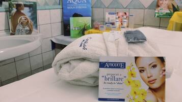 A bathroom with a sink, a towel, and various toiletries on a counter.