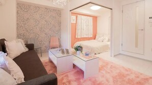 Um quarto moderno com uma cama, um guarda-roupa branco e uma mesa de centro de vidro.