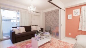 Uma sala de estar moderna com uma mesa de centro de vidro, um sofá marrom e um tapete rosa.