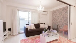 Sala de estar moderna com sofá, mesa de centro e tapete rosa.