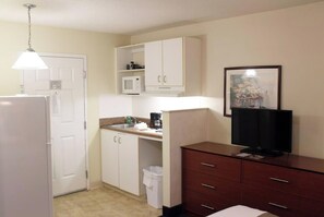 A compact kitchen with a refrigerator, microwave, sink, and a small cabinet. - Suburban Extended Stay Hotel (Charlotte)