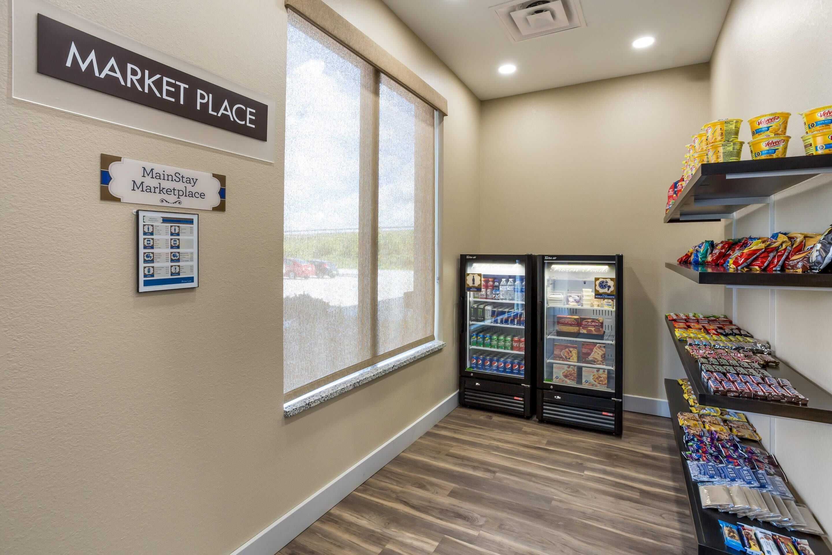 A market place area with a refrigerated display and snack shelves.