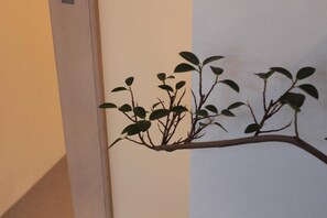 A wall-mounted branch with leaves, likely a decorative piece. - Guest House COCO Hiroshima - Hostel, Caters to Women (Hiroshima)