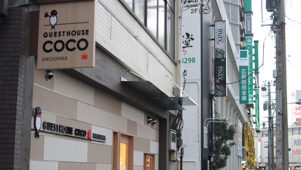 A building with a sign for "Guesthouse Coco Hiroshima" and a number "3298" on the wall. - Guest House COCO Hiroshima - Hostel, Caters to Women (Hiroshima)