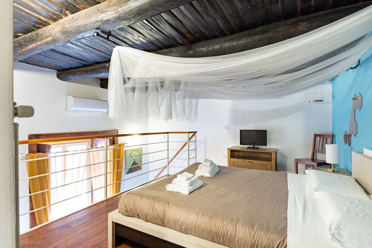 Une chambre à coucher avec un lit, une télévision, un bureau en bois et une chaise.