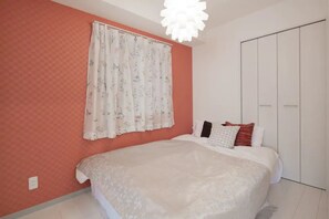 A bedroom with a large bed, a wardrobe, and a ceiling light. - Hatch NAGAHORI 701 (Osaka)