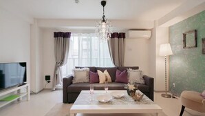 A modern living room with a sofa, coffee table, and TV. - Hatch NAGAHORI 701 (Osaka)