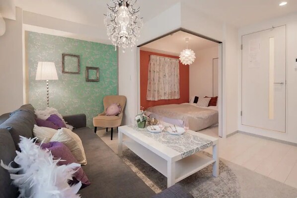 A modern bedroom with a bed, a sofa, a coffee table, and a chair. - Hatch NAGAHORI 701 (Osaka)