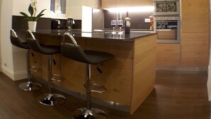 Una cocina moderna con una isla central, taburetes de bar y armarios de madera.