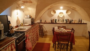 Una cocina acogedora con estufa, fregadero y comedor con sillas y mesa.