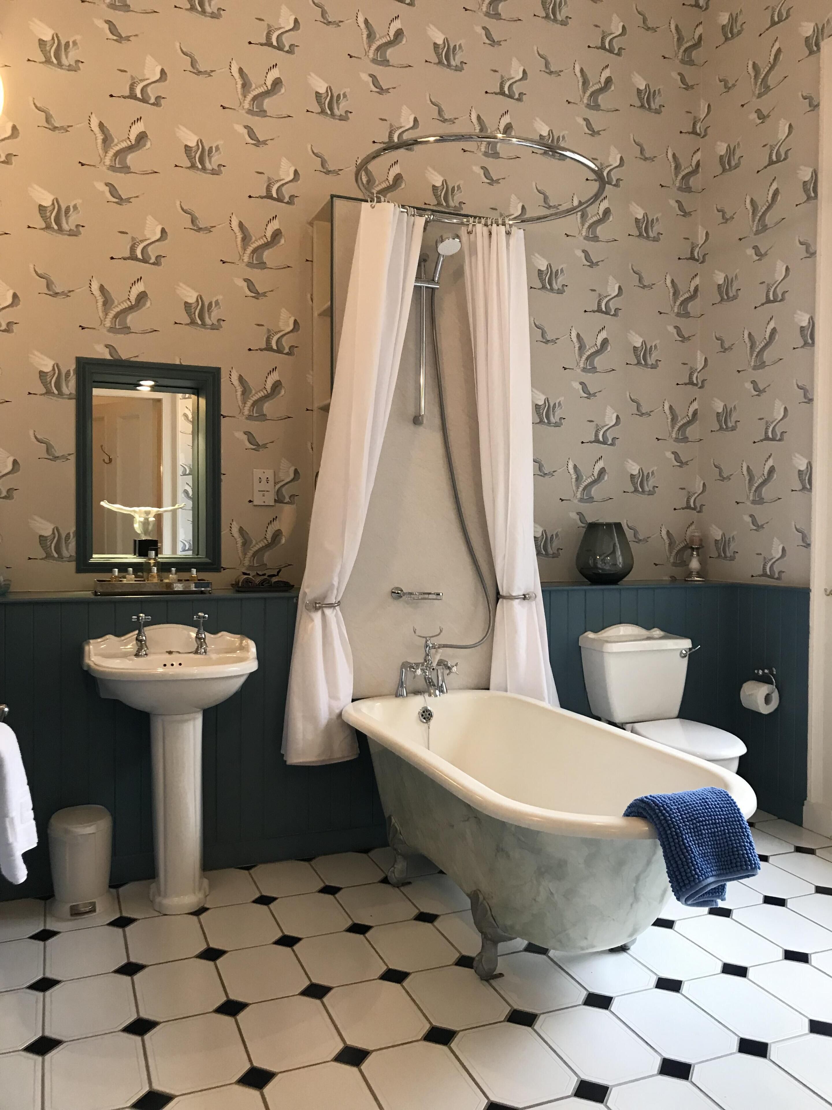 A bathroom with a freestanding bathtub, a pedestal sink, and a toilet.