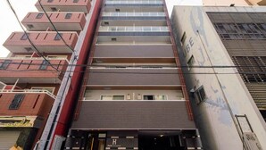 A multi-story hotel with a modern design, featuring a central entrance and balconies on each floor. - Hatch NAGAHORI 901 (Osaka)