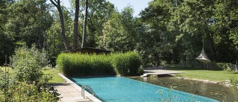 Una piscina al aire libre de temporada, tumbonas