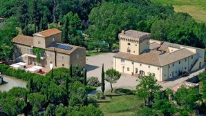 Un vaste domaine comprenant plusieurs bâtiments, dont une structure centrale en forme de tour et plusieurs bâtiments plus petits.