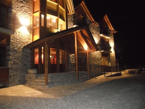 A stone building with a wooden porch and a staircase leading to the entrance. - Hotel Casa Chuldian (Sahun)