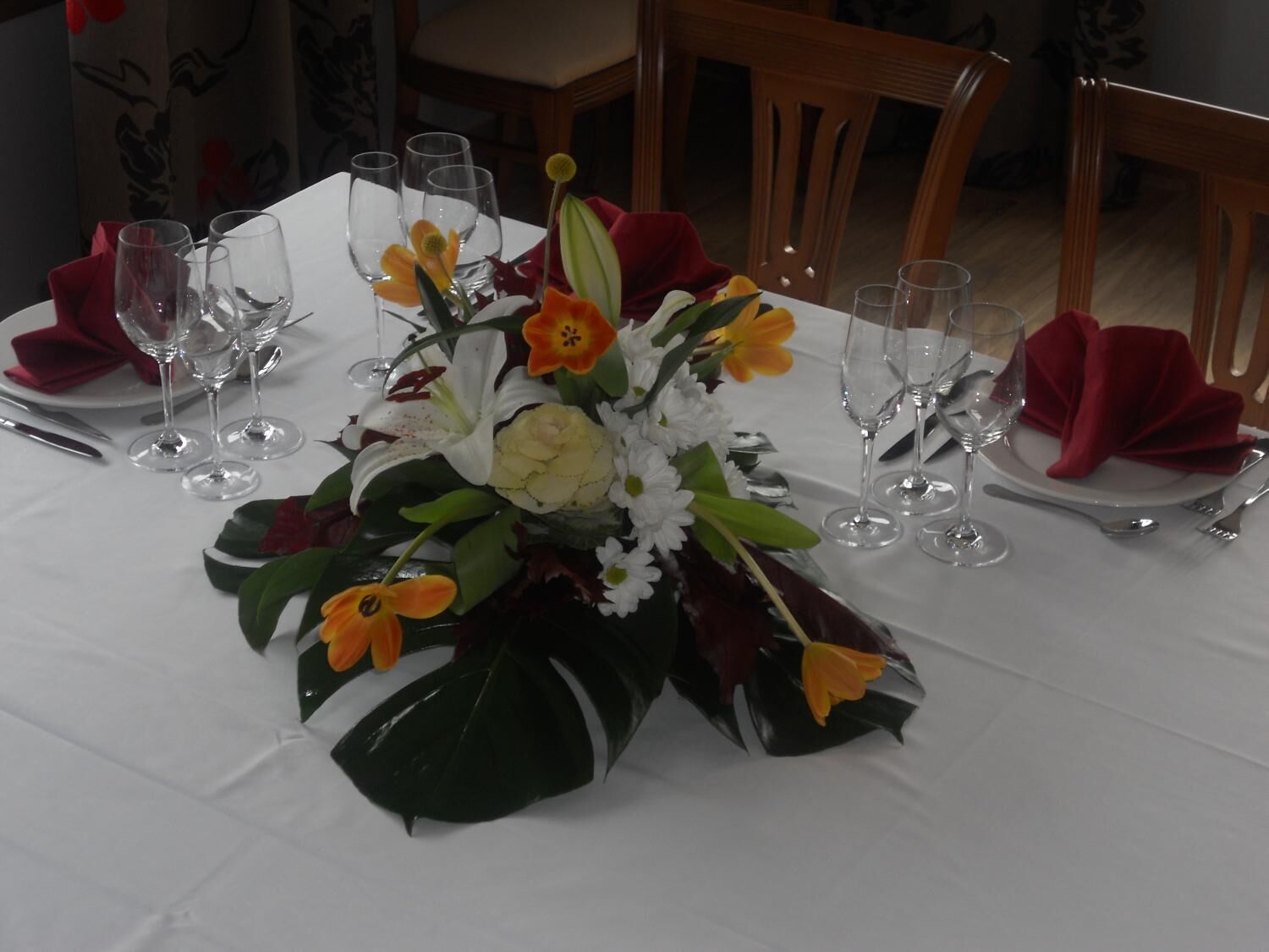A table set for a meal with a centerpiece of flowers and folded napkins.