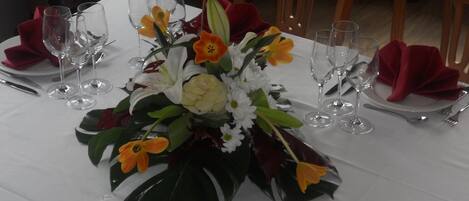A table set for a meal with a centerpiece of flowers and folded napkins.