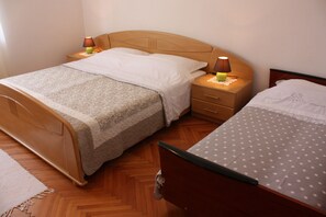 Un lit double avec une tête de lit en bois et une table de chevet avec une lampe.