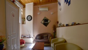 A cozy living room with a sofa, a coffee table, and two armchairs. - Hotel Electra (Piraeus)