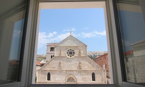 A church with a prominent circular window and two statues on the facade. - Boutique Apartments Palcic Palace (Pag)