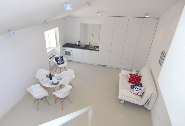 A modern, white interior with a dining area, kitchen, and living space. - Boutique Apartments Palcic Palace (Pag)