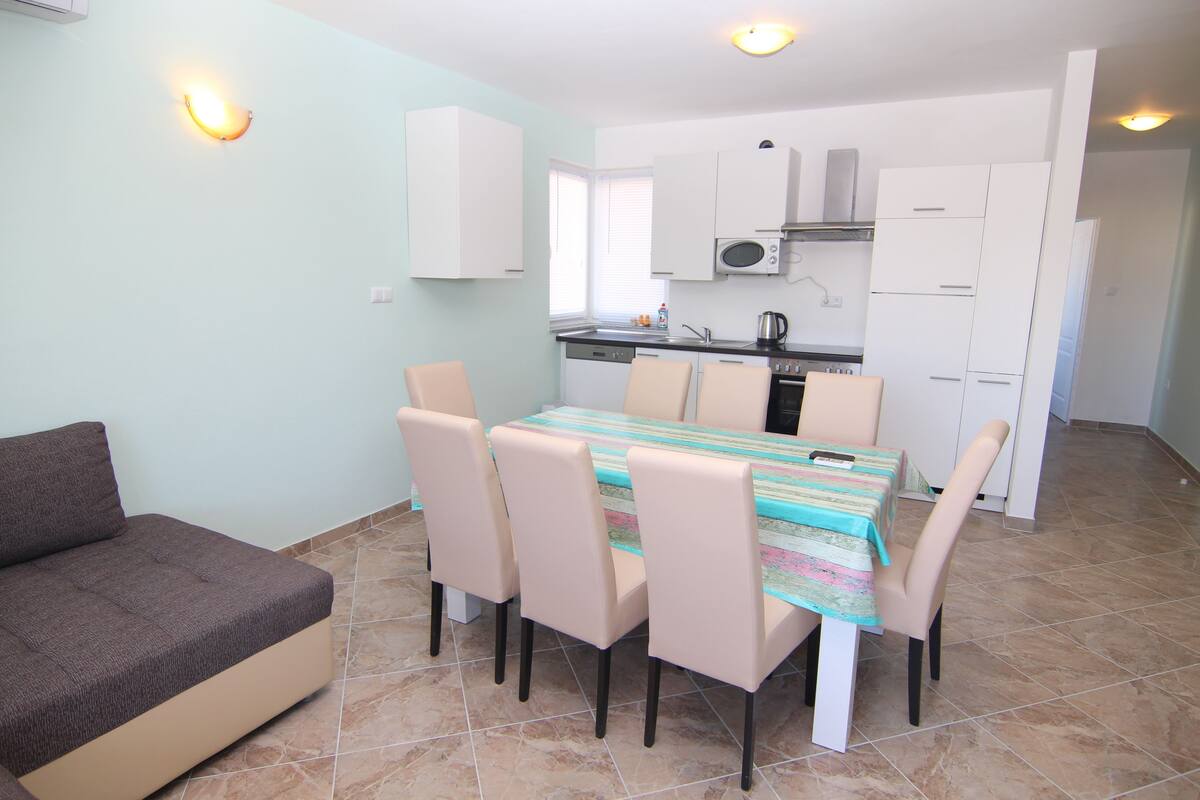 A compact living space with a dining area, kitchenette, and a sofa.