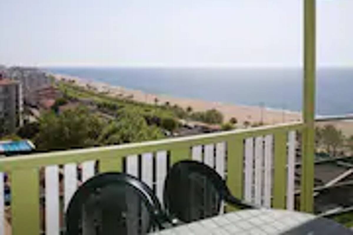 Un espacio al aire libre techado con vistas al océano. Hay dos sillas y una mesa.