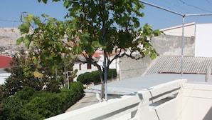 An outdoor patio with a white table and four white plastic chairs. - Apartment Jasenka (Pag)