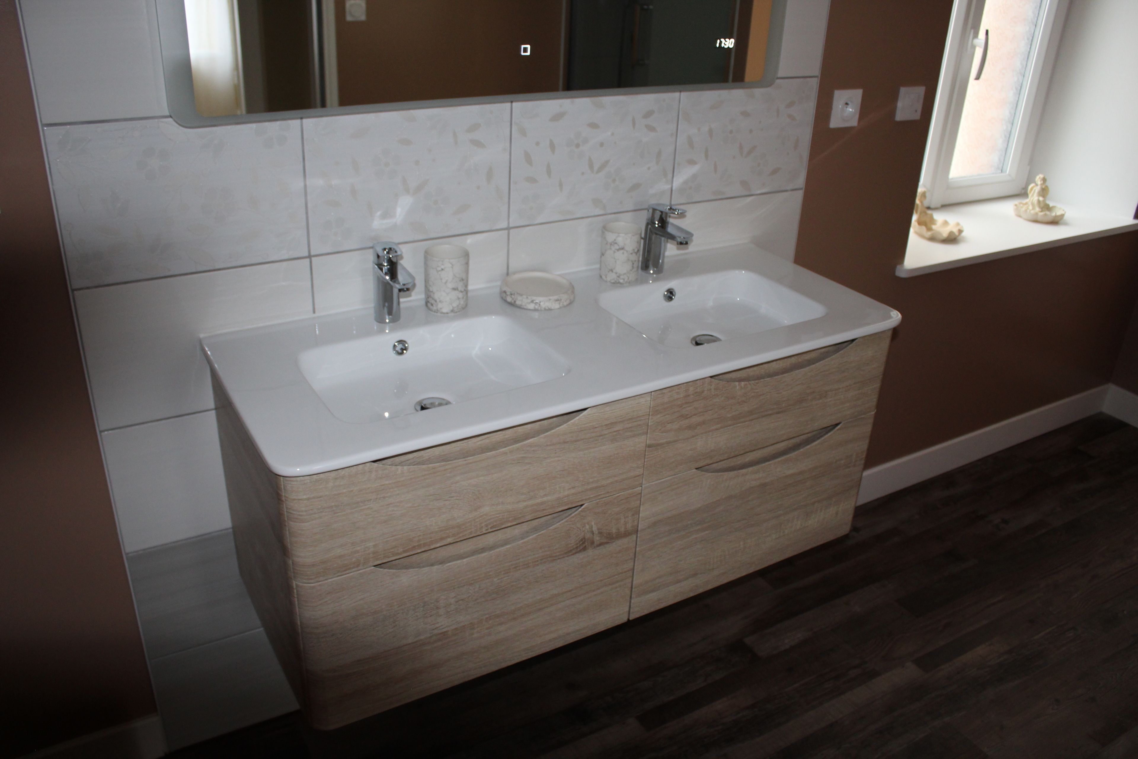 A bathroom with two sinks, a mirror above, and a window with a view.
