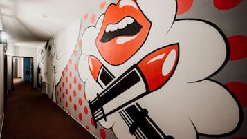A hallway with a mural featuring a stylized face and lipstick.